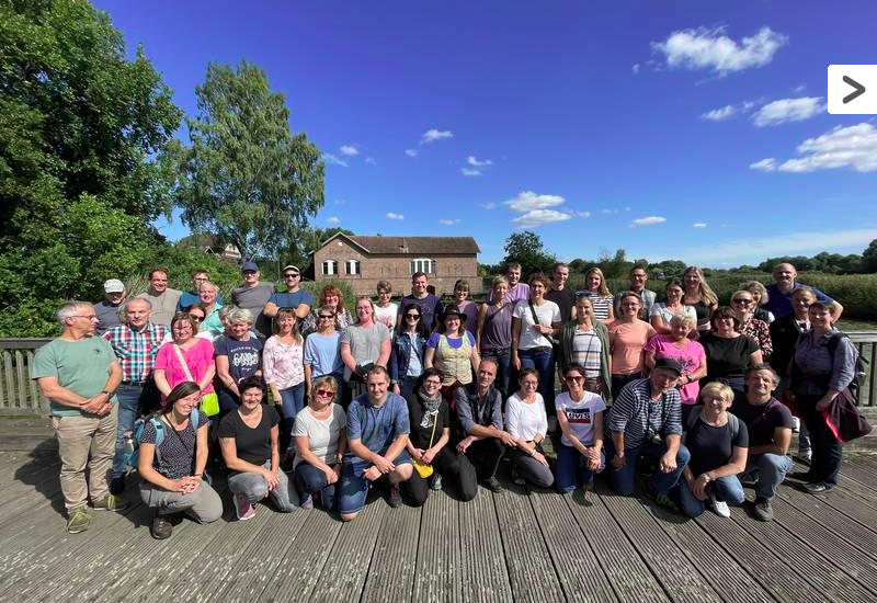 Eine Gruppe von 50 Menschen draußen in 3 Reihen
