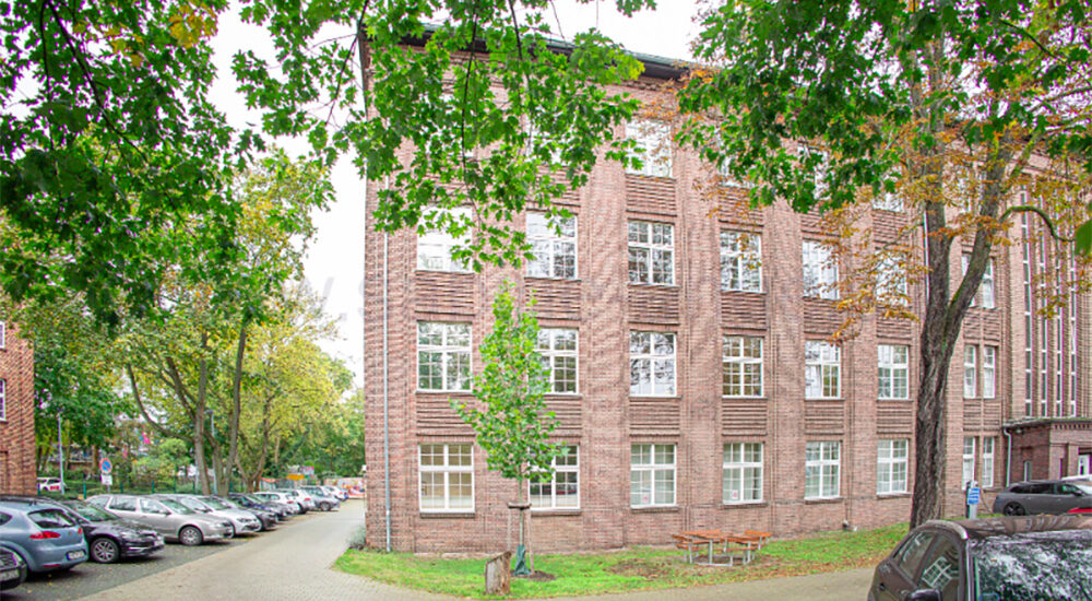 Ein Bürogebäude mit Parkplätze und Baume